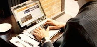 Man on a restaurant typing on a computer