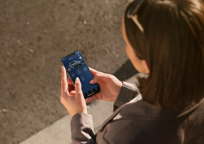 A person is shown interacting with a smartphone to connect to a Lincoln vehicle via the Lincoln Way® App. | Parks Lincoln of Gainesville in Gainesville FL