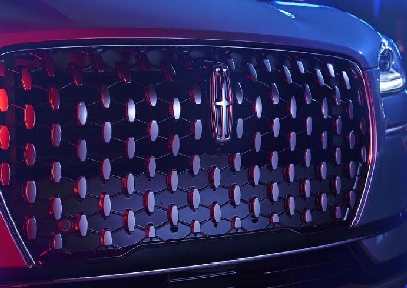The grille of a 2025 Lincoln Corsair® SUV reflects neon light at night. | Parks Lincoln of Gainesville in Gainesville FL