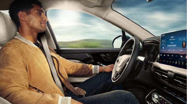 A person is shown using Lincoln BlueCruise hands-free highway driving technology on a divided highway called a Hands-Free Blue Zone. | Parks Lincoln of Gainesville in Gainesville FL