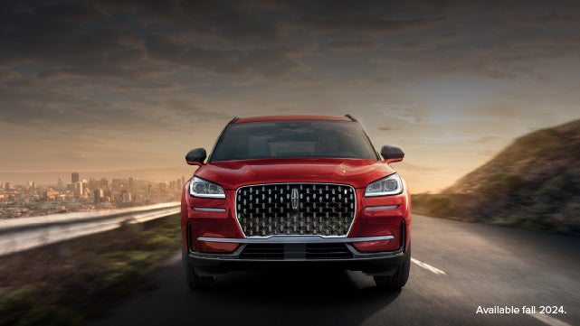 A 2025 red Lincoln Corsair® SUV is being driven down a road at sunset. | Parks Lincoln of Gainesville in Gainesville FL