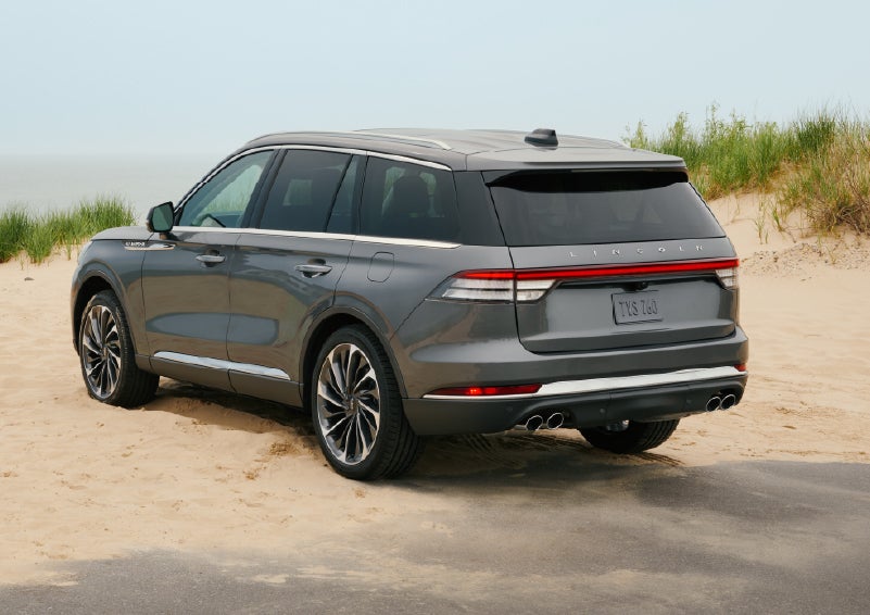 A 2027 Lincoln Aviator® SUV is parked next to sand dunes. | Parks Lincoln of Gainesville in Gainesville FL