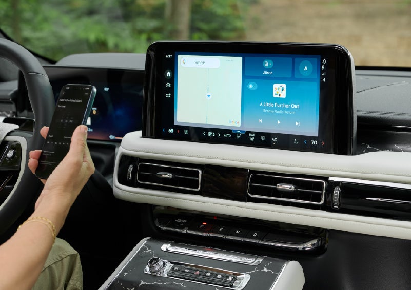 A person pairs thier phone with the center touchscreen of a 2027 Lincoln Aviator® Black Label™ SUV | Parks Lincoln of Gainesville in Gainesville FL